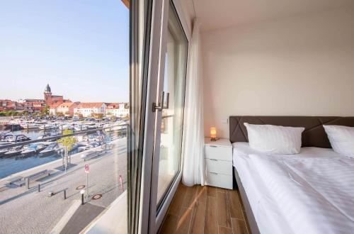 a bedroom with a window with a view of a harbor at Sieglinde - Apartment in der Hafenresidenz mit Balkon & Wellness in Waren