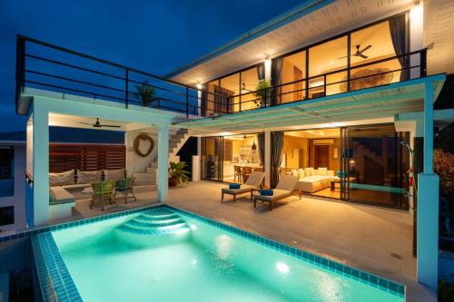 a house with a swimming pool in front of it at Tahiana Villa in Haad Tian