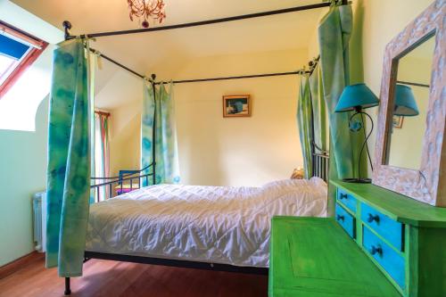 a bedroom with a canopy bed and a mirror at Ty Océane 2 - 5min du Port dEtel in Étel