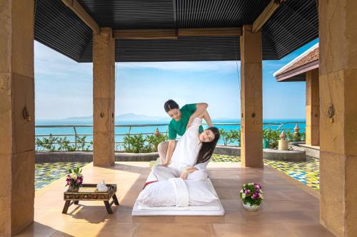a bride and groom jumping on a bed at a resort at Royal Wing Suites & Spa Pattaya in Pattaya South