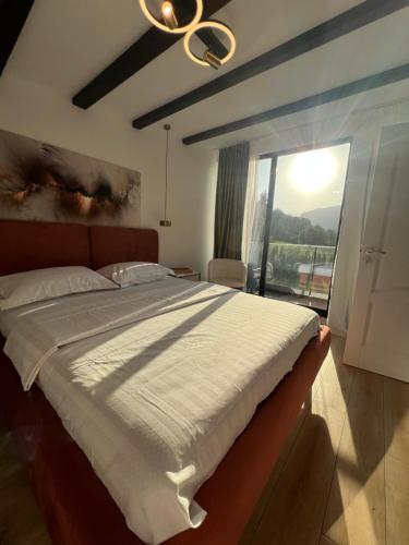 a bedroom with a large bed with a large window at Zago Alpin in Câmpulung Moldovenesc