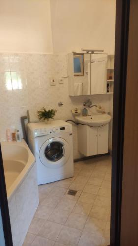 a bathroom with a washing machine and a sink at Kadovský dvůr in Sněžné