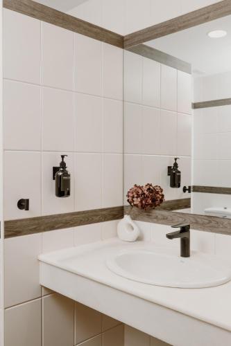 a white bathroom with a sink and a mirror at Hotel Convento de Miranda in Miranda de Ebro