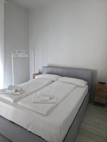 a large white bed with two white towels on it at Casa Dream - Milan in Cesano Boscone