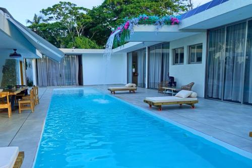 ein Swimmingpool mit Terrasse und ein Haus in der Unterkunft Villa Modena in Las Terrenas