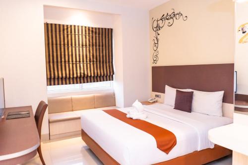a bedroom with a large bed and a window at Sparks Odeon Sukabumi, ARTOTEL Curated in Sukabumi