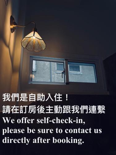 a window in a room with a light and a lamp at KM Hostel in Chiayi City