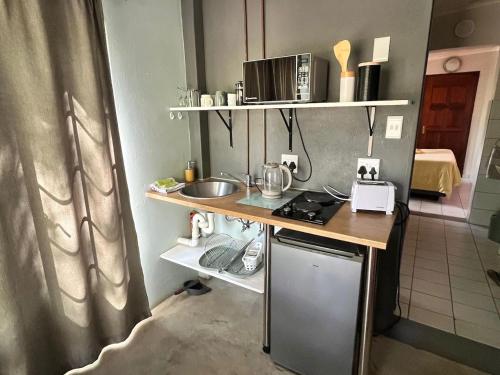 a small kitchen with a counter and a table at Hello Kruger Skilpad in Marloth Park