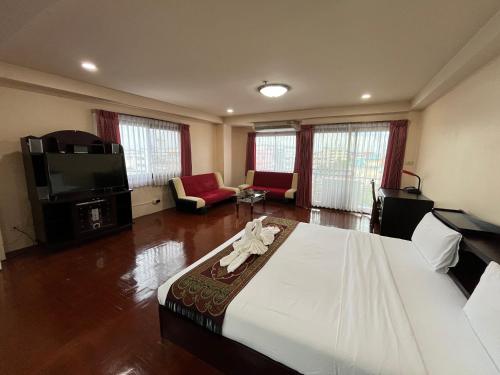 a bedroom with a large bed and a living room at Yamadaya Apartment in Phra Nakhon Si Ayutthaya