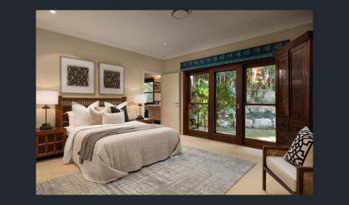 ein Schlafzimmer mit großem Bett und Fenster in der Unterkunft Rancho del Cielo in Carbrook