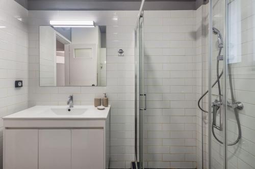Un baño blanco con lavabo y ducha. en OneZeroTwo by Zoia Living, en Atenas