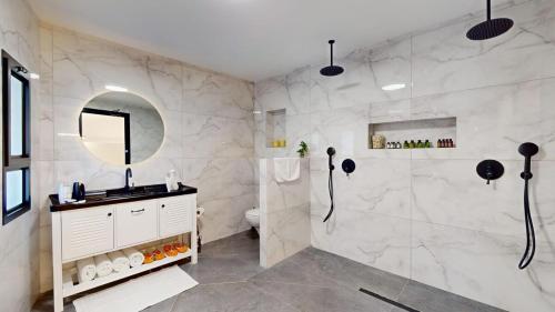 a bathroom with a shower and a sink and a mirror at זוהר בגליל-מיני וילה עם בריכה וג'קוזי בעין יעקב in ‘Ein Ya‘aqov