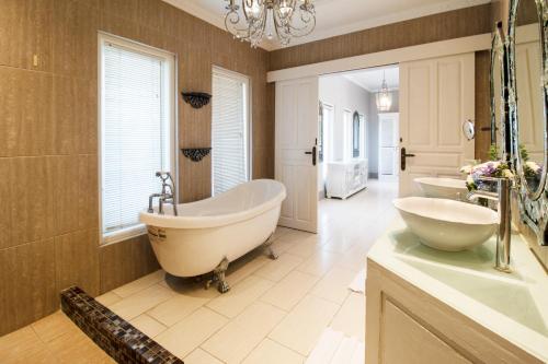 un bagno con due lavandini e una vasca di Rose Villa Seminyak a Seminyak