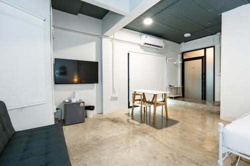 a room with a table and a tv and a bed at Yellow Place Sukhumvit 2 - BTS Nana Pro in Bangkok