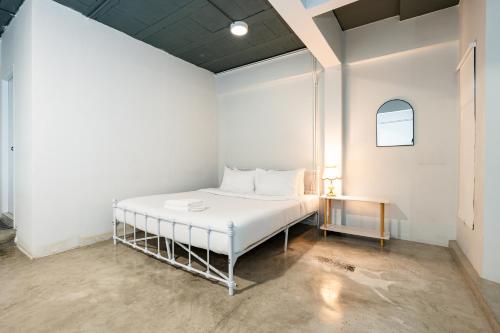 a white bed in a white room with a table at Yellow Place Sukhumvit 2 - BTS Nana Pro in Bangkok