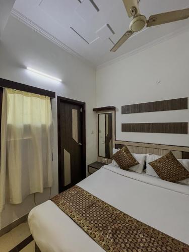 a bedroom with a large white bed and a window at Hotel The Golden Bird Executive in Agra