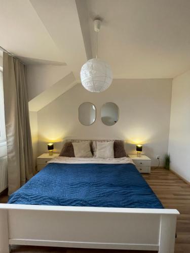 a bedroom with a bed with blue sheets and mirrors at 7 people - 1 price - Cozy attic apartment in Prešov