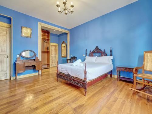 Un dormitorio con paredes azules y una cama y una mesa. en Casa Museo by Clabao, en Viana