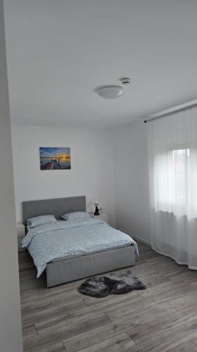 a bedroom with a bed and a white wall at Casa Magurele 4 in Măgurele