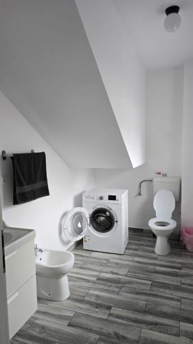 a bathroom with a toilet and a washing machine at Casa Magurele 4 in Măgurele