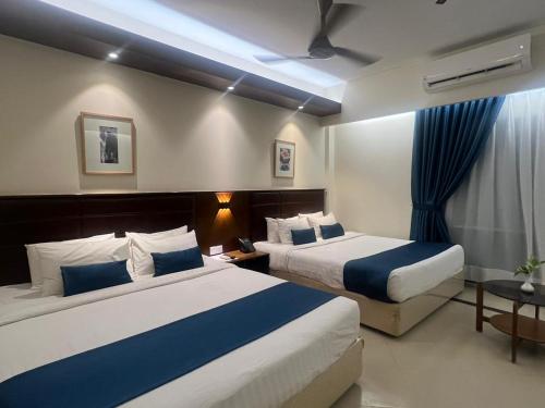 una camera d'albergo con due letti e un tavolo di Hotel Kollol by J&Z Group a Cox's Bazar