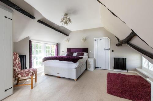ein weißes Schlafzimmer mit einem Bett und einem Fenster in der Unterkunft Castle Hill Cottage on a Scheduled Monument in Kenilworth