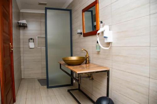 a bathroom with a bowl sink and a shower at Distinction Gardens in Siaya