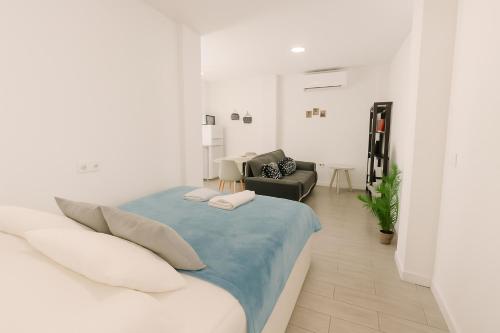 a white bedroom with a bed and a living room at Suite by Hawkins interior 1º A in Algeciras