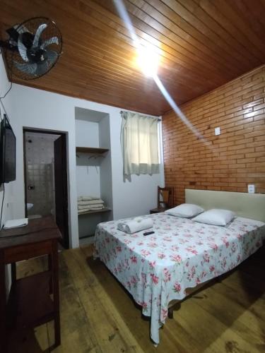 a bedroom with a bed and a wooden ceiling at Pousada Encanto Das Águas in São Lourenço