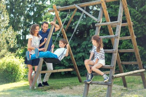 a group of people sitting on a swing at Wellness Hotel Diana in Velké Losiny
