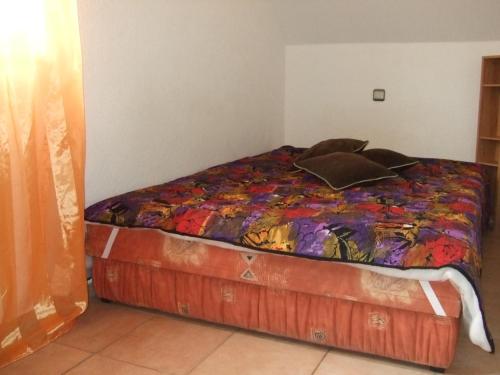 a bed with a colorful comforter in a room at A2-Vermietung in Peine