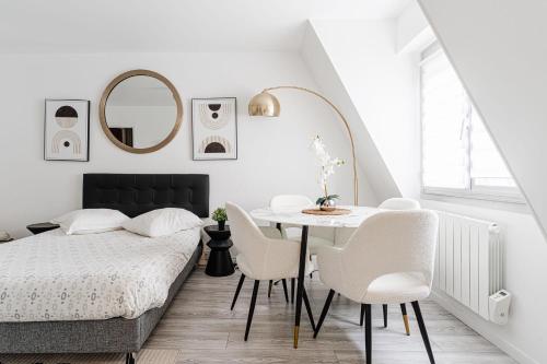 a bedroom with a bed and a table and chairs at Bright Studio 3P – Close to Deauville Beach in Deauville