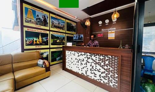 a man sitting at a bar in a restaurant at FabHotel NRM Residency in Mysore