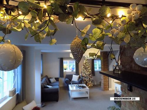 ein Wohnzimmer mit Weihnachtsschmuck, der von der Decke hängt in der Unterkunft Double Award Winning 1700's Grd 2 listed cottage near Stonehenge in Amesbury