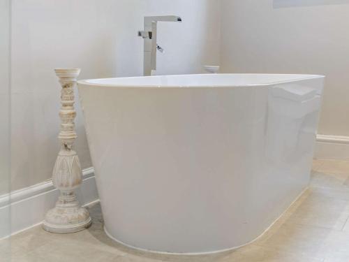 a white bath tub in a bathroom with a sink at 2 Bed in Cartmel 73154 in Cartmel