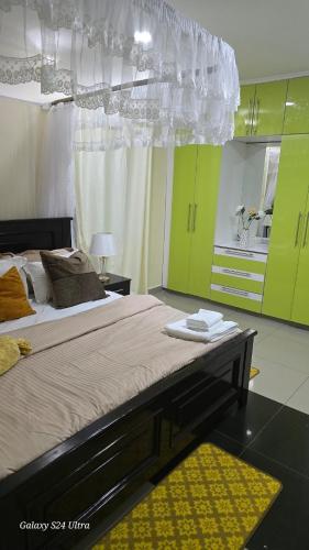 a bedroom with a large bed with green cabinets at FAMILY CLICK HOMEs in Lilongwe