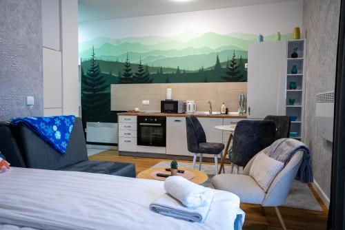 een kamer met een bed en stoelen en een keuken bij Mountain goat Bjelašnica in Bjelašnica