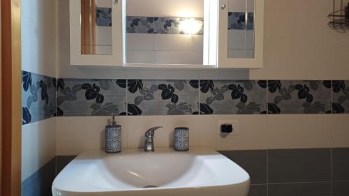 a white sink in a bathroom with a mirror at Profumo di Zagara Acireale in Acireale