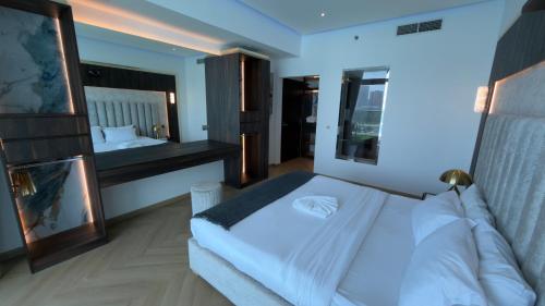 a bedroom with a white bed and a large mirror at Highend Azure Stay Palm Jumeirah in Dubai