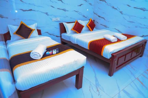 two twin beds in a room with a mural at RR Residency in Vishāram