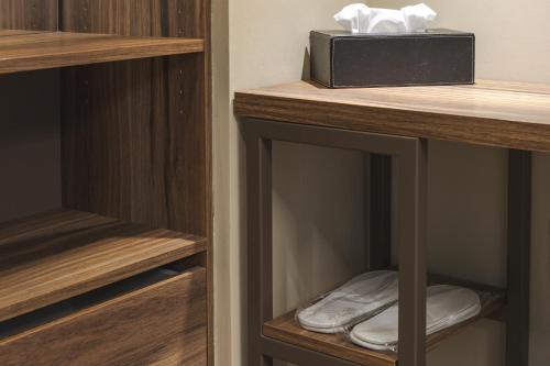 a closet with wooden shelves and a box on top at 9 stanze - Boutique Rooms in Trieste