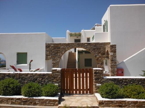 una casa con un cancello in legno di fronte di St George Antiparos Apartments and studios ad Agios Georgios
