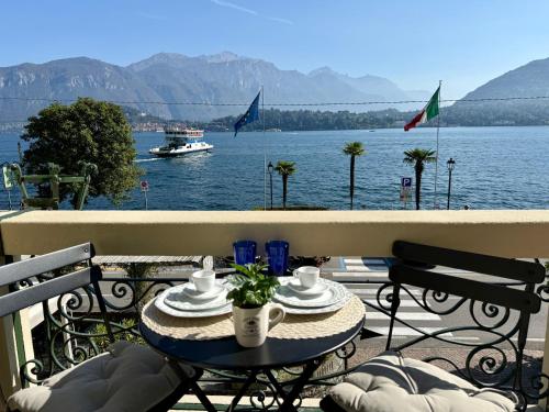 a table on a balcony with a view of the water at BELLE ILE LAKE VIEW SUITE in Griante Cadenabbia