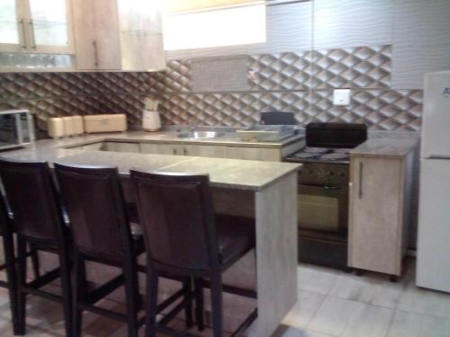 a kitchen with a island in the middle of a kitchen at Sintokha Guest House in Newcastle