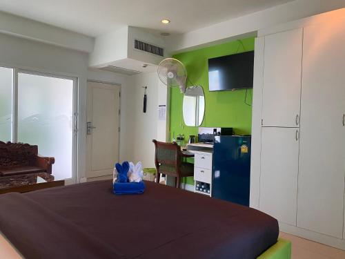 a room with a bed and a kitchen with green walls at Access Inn Pattaya in Pattaya