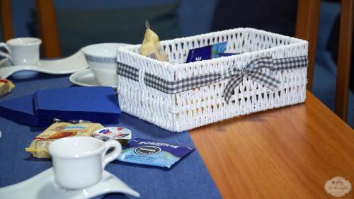 een witte mand op een tafel met een kopje bij Le Cortiglie Affittacamere in Piedimonte dʼAlife