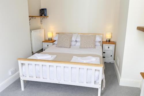 ホーリーにあるRioland Apartment near Gatwickの白いベッドと2つのナイトスタンドを備えた寝室