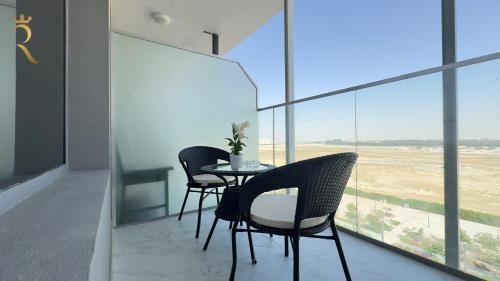 a table and chairs in a room with a view of the desert at Luxe 2BR Oasis - Rooftop Elegance in Abu Dhabi