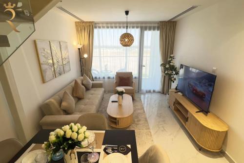 a living room with a couch and a tv at Luxe 2BR Oasis - Rooftop Elegance in Abu Dhabi