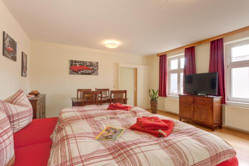 ノイルピーンにあるAltstadt Ferienwohnungのベッドルーム1室(赤いタオルが付いたベッド1台付)